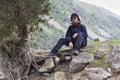 Young man in summer mountains at sunset and enjoying view of nature. Happy hiker, life goal, success, freedom and happiness Royalty Free Stock Photo