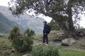 Young man in summer mountains at sunset and enjoying view of nature. Happy hiker, life goal, success, freedom and happiness Royalty Free Stock Photo