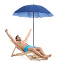 Young man on sun lounger under umbrella  white background. Beach accessories Royalty Free Stock Photo