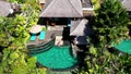 Young man sunbathing by the pool in luxury bungalow in tropical garden. Asian man tanning enjoying summer day