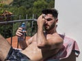 Young Man Sunbathing and Sprinkling water on himself