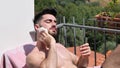 Young Man Sunbathing and Sprinkling water on himself