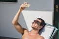 Young Man Sunbathing and Taking Selfie picture Royalty Free Stock Photo