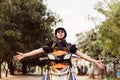 Young man in sunglasses and helmet riding motorcycle raising hands up as winner and success.