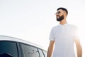 Young man in sunglasses standing near his car outdoors, Handsome man next to the car, man on the background of the car Royalty Free Stock Photo