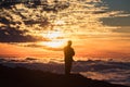 Young man on sunset above the clouds in the mountains Royalty Free Stock Photo