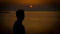 Young man sunset silhoutte on a coast