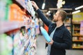 Young man in the supermarket in the household chemicals department. Large selection of products. A brunette in a glasses Royalty Free Stock Photo