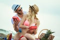 Young man suprising his girlfriend with gift on the beach Royalty Free Stock Photo