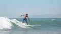 Young man on surfboard sliding on the waves on a clear day Royalty Free Stock Photo