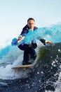 Young man surfer in classic suit with blue smoke bomb in his hand rides on the wave. Happy clerk escaped from stuffy Royalty Free Stock Photo