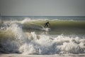 Young man surfing epic wave his body is out of focus the foreground