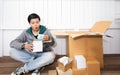 Young man surprised opening box and looking inside and unpacking the package received online shopping parcel opening boxes buying Royalty Free Stock Photo