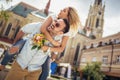 Young man surprising woman with flowers