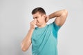 Young man with sweat stain on his clothes against light background Royalty Free Stock Photo