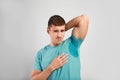 Young man with sweat stain on his clothes against light background Royalty Free Stock Photo