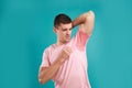 Young man with sweat stain on his clothes against blue background. Using deodorant Royalty Free Stock Photo