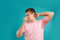 Young man with sweat stain on his clothes  light blue background. Using deodorant Royalty Free Stock Photo