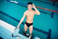 Young man swimmer wearing goggles training In swimming pool blue water Royalty Free Stock Photo