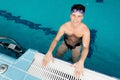 Young man swimmer wearing goggles training In swimming pool blue water Royalty Free Stock Photo