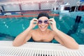 Young man swimmer wearing goggles training In swimming pool blue water Royalty Free Stock Photo