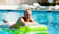 Young man is swimming with air mattress in pool Royalty Free Stock Photo