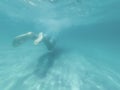 Young man is swimming in the blue deep sea. Underwater shoot