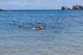 Young man swimming with a mask on the beach