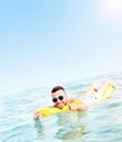 Young man swimming on a matress