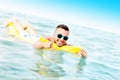 Young man swimming on a matress