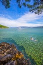 Young man swimming in stone beach with crystal clear tourquise s Royalty Free Stock Photo