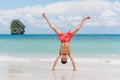 Young man in swimming trunks stands on his hands on sand against paradise tropical landscape - Railay Beach, Krabi, Thailand Royalty Free Stock Photo