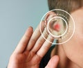 Young man with symptom of hearing loss on color background