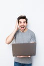 Young man in a table with a laptop celebrating a victory isolated white background Royalty Free Stock Photo