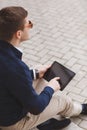 Young man with tablet computer sitting on stairs Royalty Free Stock Photo