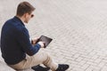 Young man with tablet computer sitting on stairs Royalty Free Stock Photo