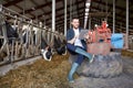 Young man with tablet pc and cows on dairy farm Royalty Free Stock Photo