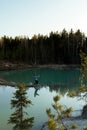 Young man take travel photos - Beautiful turquoise lake in Latvia - Meditirenian style colors in Baltic states -