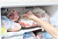 A young man takes out convenience foods from the freezer to prepare dinner in the microwave