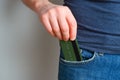 A young man takes out a credit card from his blue jeans pocket. Close-up on a man hand hand taking out a payment card from Royalty Free Stock Photo