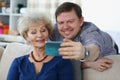 Young man takes selfie on smartphone with his mom Royalty Free Stock Photo