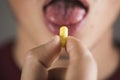 A man takes a yellow pill