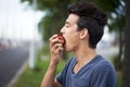 Taking a bite. A young man taking a bite of an apple while waiting for the bus. Royalty Free Stock Photo