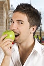 Young man taking bite of green apple Royalty Free Stock Photo