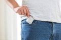 Young man taking condom out of pocket in jeans Royalty Free Stock Photo