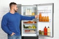 Young man taking juice out of refrigerator Royalty Free Stock Photo