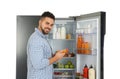 Young man taking juice out of refrigerator on white Royalty Free Stock Photo