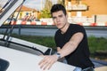 Young man taking luggage and bag out of car trunk Royalty Free Stock Photo