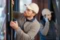 young man taking measure window for blinds installation