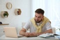 Young man taking notes during webinar at table indoors Royalty Free Stock Photo